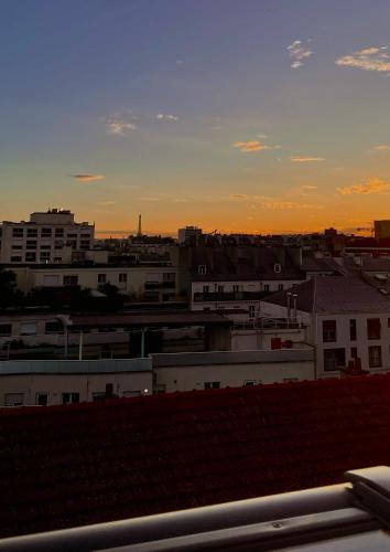 - une vue sur les toits de la ville au coucher du soleil dans l'établissement Heart of Paris with View - Renovated, à Paris