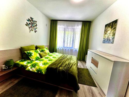 um quarto com uma cama com lençóis verdes e uma janela em Blue Sunrise Comfort em Varna City