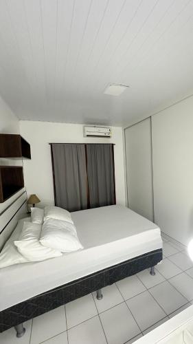 a bedroom with a large bed with white sheets and pillows at Sua Casa Francês in Marechal Deodoro