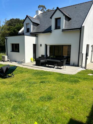 a white house with a table and chairs in the yard at Maison spacieuse, centre sarzeau in Sarzeau