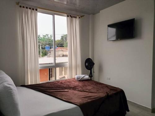 a bedroom with a bed and a large window at UrbanWork Retreat in Guaduas