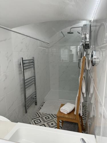 a bathroom with a shower with a bench in it at Jewells Guest Accommodation in Plymouth