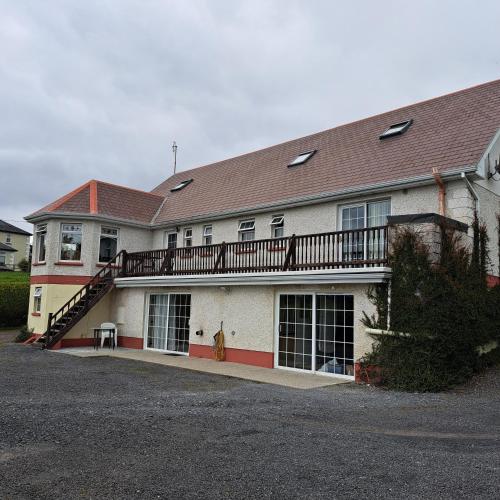 a building with a balcony on the side of it at Spacious 6-Bed House 10 minutes from Knock Airport in Ballaghaderreen