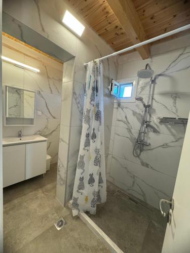 a bathroom with a shower curtain and a sink at Avra Benitses Beach Apartment in Benitses