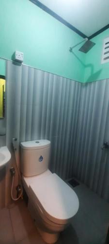 a bathroom with a white toilet and a sink at Greenbury Kite Hostel & Restaurant in Kalpitiya
