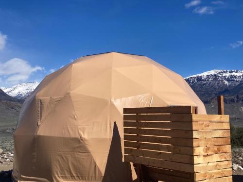 a large dome tent with mountains in the background at Pure Heart Retreat in Cody