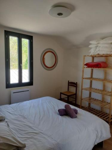 een slaapkamer met een groot wit bed en een plank bij Maison Bel Air in Moliets-et-Maa