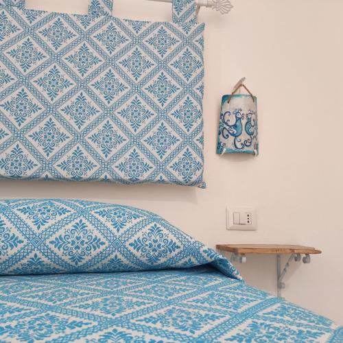 a bed with a blue and white pattern on the wall at Agriturismo Quattro Mori in Porto Torres