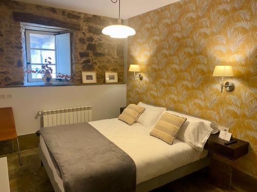 - une chambre avec un lit et une fresque murale dans l'établissement Hotel Pazo de Bieite, à Boimorto