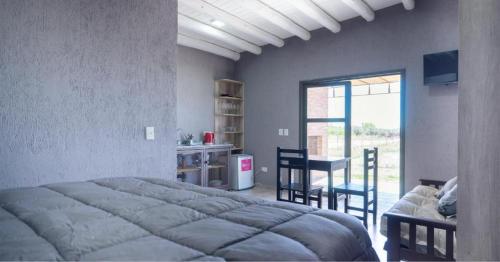 邁普的住宿－Vista Chachingo Lodge，卧室配有一张床和一张桌子及椅子