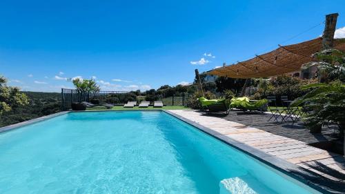 une piscine avec des chaises et un parasol dans l'établissement Villa climatisée piscine billard ping-pong, à Saint-Maximin