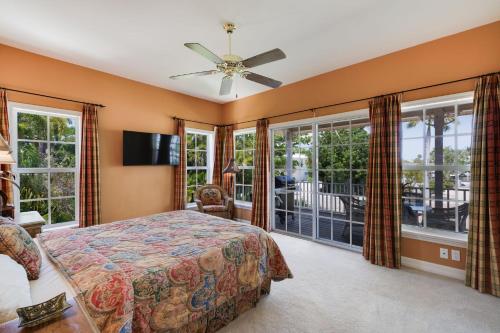 a bedroom with a bed and large windows at Grandma Dot's House- Marina Villa with Pool and Bikes in Sanibel
