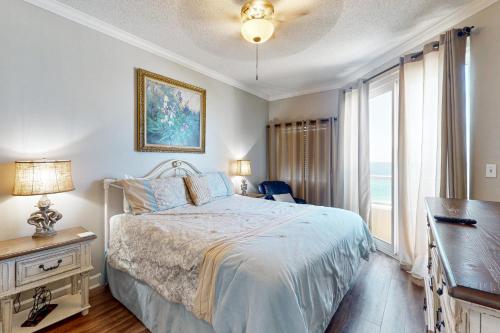 a bedroom with a bed and a desk and a window at Enclave 605 in Orange Beach