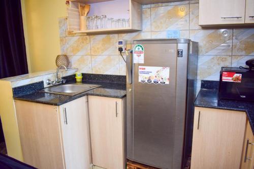 uma cozinha com um frigorífico de aço inoxidável e um lavatório em Kahawa sukari luxury home em Nairobi