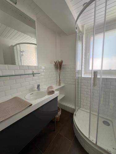 een witte badkamer met een wastafel en een douche bij Appartement 60m2 - Carré d'Or Cathédrale in Straatsburg