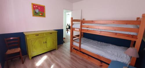 - une chambre avec des lits superposés et une armoire jaune dans l'établissement Domaine du grand roc- Gîte 3- La sitelle, à Saint-Saud-Lacoussière