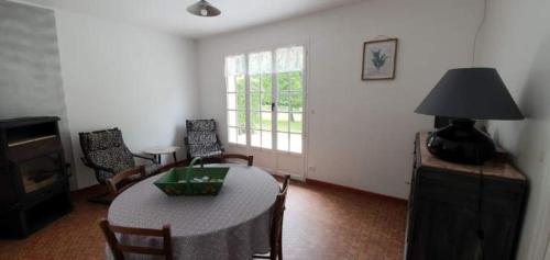 - un salon avec une table, des chaises et une lampe dans l'établissement Domaine du grand roc- Gîte 3- La sitelle, à Saint-Saud-Lacoussière