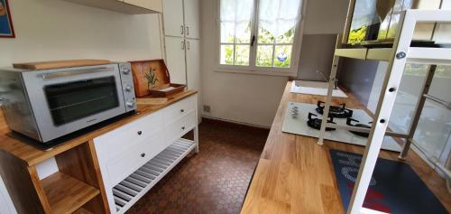 une chambre avec une télévision sur un bureau avec un micro-ondes dans l'établissement Domaine du grand roc- Gîte 3- La sitelle, à Saint-Saud-Lacoussière