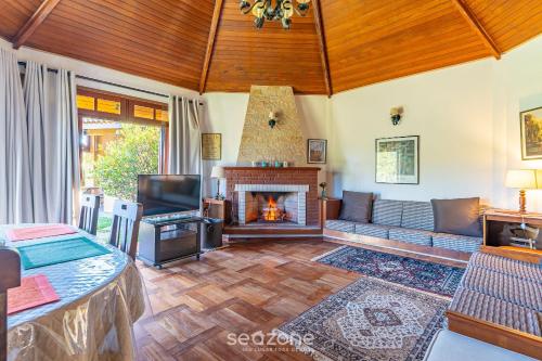 Una sala de estar con un sofá y una chimenea. en MCD - Casas en Campos do Jordão, en Campos do Jordão