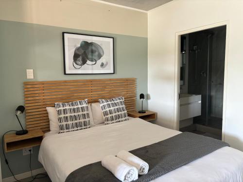1 dormitorio con 1 cama grande y toallas. en Coral Point Executive studio Apartment, en Umdloti