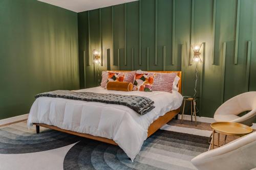 a bedroom with a large bed with green walls at Groovy Condo in the Vibrant NuLu District in Louisville
