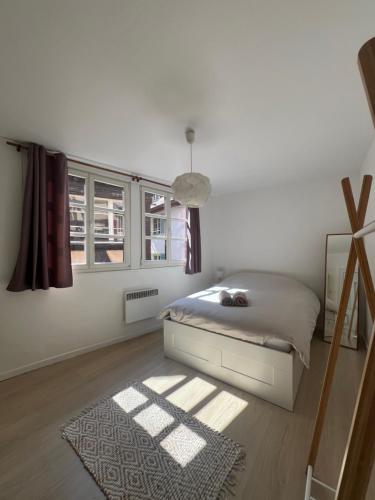 een witte slaapkamer met een bed en een raam bij Appartement 60m2 - Carré d'Or Cathédrale in Straatsburg