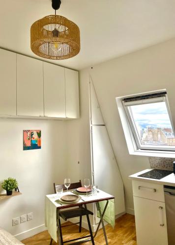 une cuisine avec une table avec des verres à vin dessus dans l'établissement Heart of Paris with View - Renovated, à Paris