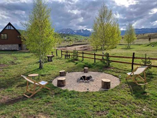 a fire pit in a field next to a fence at Villas Sunny Hill in Žabljak
