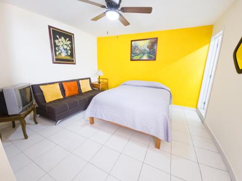 a bedroom with a bed and a yellow wall at Esquina del Pintor in Guadalajara