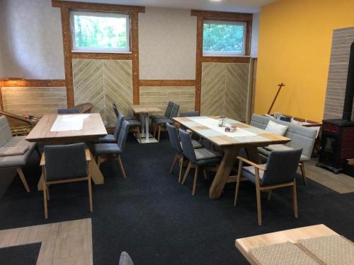 a dining room with tables and chairs and windows at DNM Inn in Koryčany