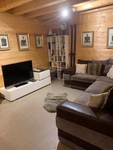 un salon avec un canapé et une télévision à écran plat dans l'établissement Chalet Serin, à Saint-Jean-dʼAulps