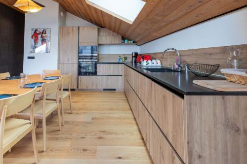 une cuisine avec un comptoir, une table et des chaises dans l'établissement Etania 401 beautiful penthouse apartment in Meribel Morel, à Méribel