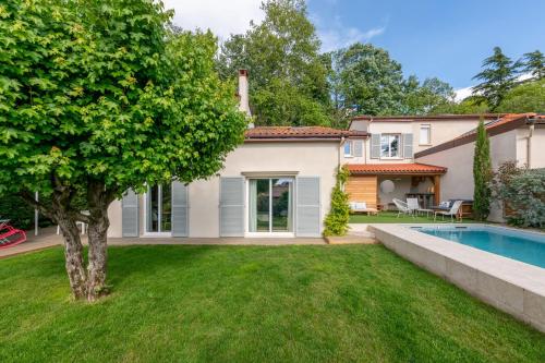 a house with a swimming pool and a yard at Villa Juliette - Welkeys in Écully