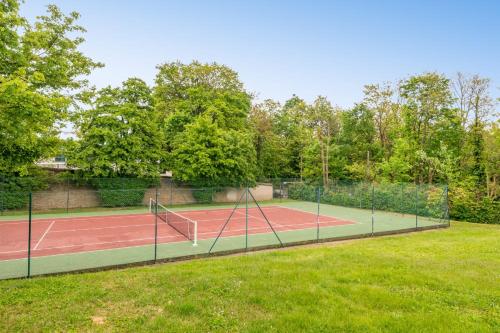 a tennis court with two tennis courts at Villa Juliette - Welkeys in Écully