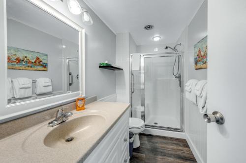 ein Bad mit einem Waschbecken und einer Dusche in der Unterkunft Sand & Sea: Beach Dreams (112) in Seaside