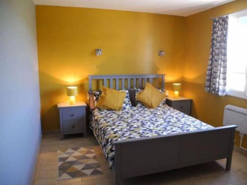 - une chambre avec un lit aux murs jaunes et 2 lampes dans l'établissement La Maison Alex, à Castelnau-de-Guers