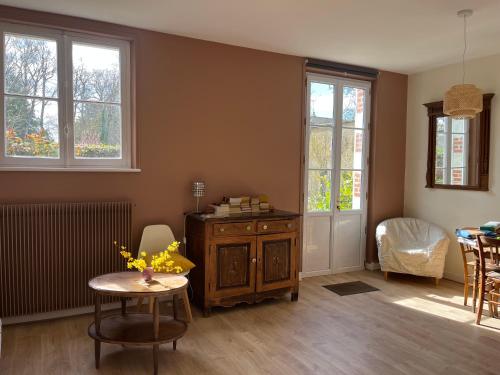 un salon avec une table, des chaises et des fenêtres dans l'établissement Chez Gilles et Anne, à Onzain