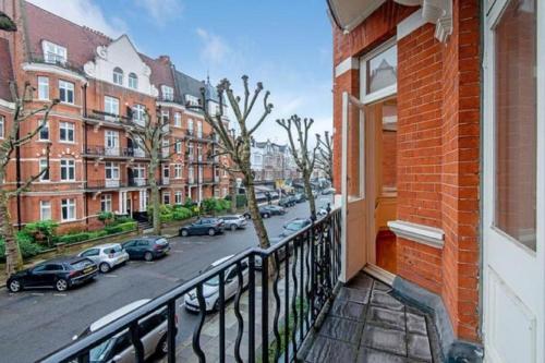 Elle comprend un balcon offrant une vue sur une rue de la ville. dans l'établissement HYDE PARK, OXFORD STREET, PADDINGTON, BEAUTIFUL 3 BEDROOMS,BALCONY, 2 BATH, MANSION BLOCK, MAIDA VALE, W9 NW8 LORDs CRICKET, à Londres