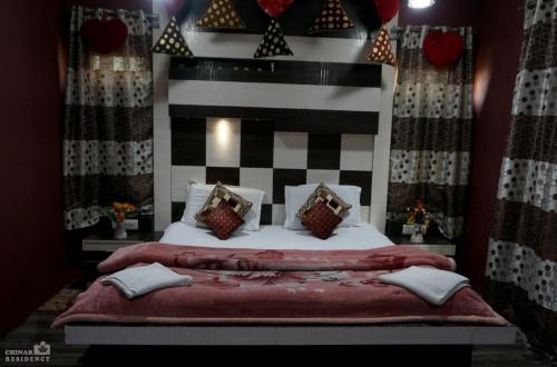斯利那加的住宿－The Chinar Residency，一间卧室配有一张带床头板和枕头的床