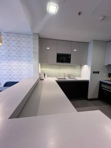 a kitchen with a white counter top and a sink at Cozy Stay in Manama