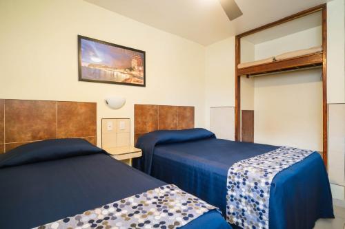 馬薩特蘭的住宿－馬薩特蘭酒店，一间卧室设有两张床,墙上配有电视。