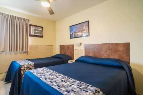a hotel room with two beds and a tv at Hotel Mazatlan in Mazatlán