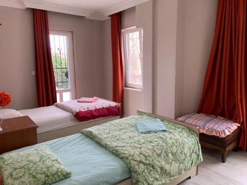 um quarto com 2 camas e uma janela com cortinas vermelhas em Şile Kumbaba'da Özel Havuz Tamamen müstakil Villa em Şile