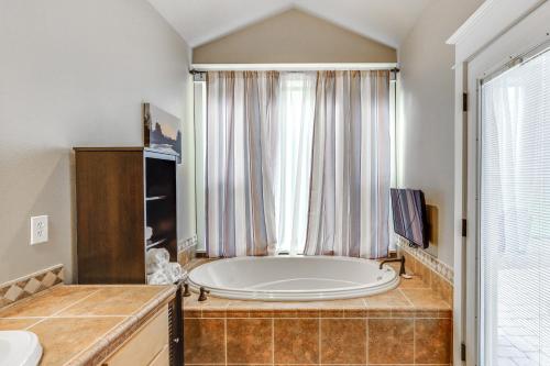 a large bath tub in a bathroom with a window at Redmond Golf Getaway - Near Smith Rock State Park! in Redmond