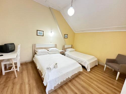 a room with two beds and a desk and a computer at Central Guest House in Figueira da Foz