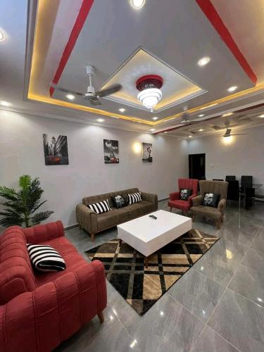 a living room with red furniture and a white table at As résidence meubles E p in Ouagadougou