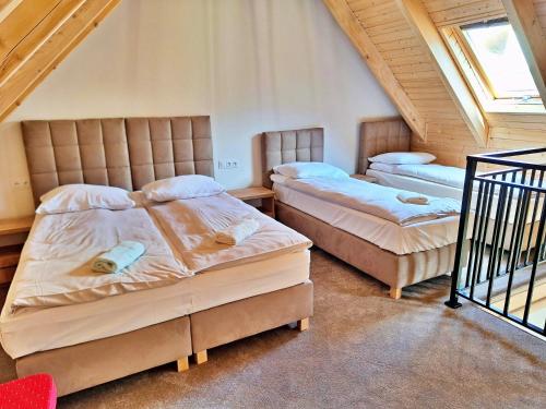 a bedroom with two beds in a attic at Zefirowe Wzgórze in Polańczyk