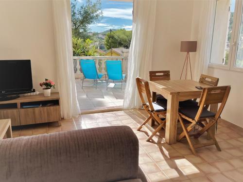 ein Wohnzimmer mit einem Tisch, Stühlen und einem TV in der Unterkunft La Casa Calanquaise - Mer à 250m accessible à pied - T2 Spacieux indépendant - Terrasse Ombragée in Ensuès-la-Redonne