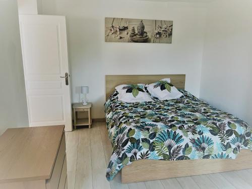 1 Schlafzimmer mit einem Bett mit Blumenbettdecke in der Unterkunft La Casa Calanquaise - Mer à 250m accessible à pied - T2 Spacieux indépendant - Terrasse Ombragée in Ensuès-la-Redonne