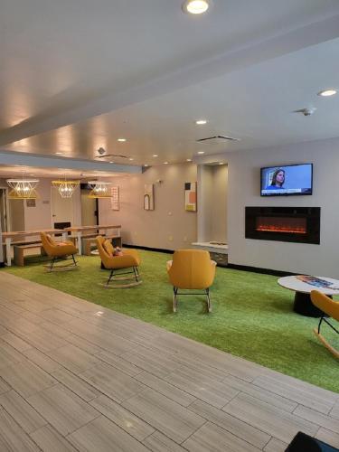 een lobby met stoelen en een flatscreen-tv bij Spark by Hilton Erie in Erie